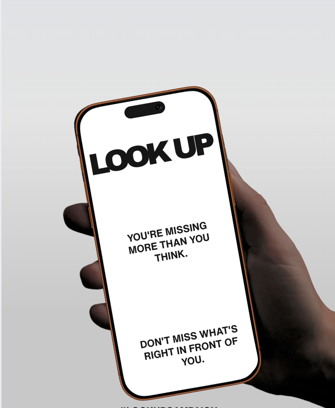 Hand holding a phone displaying the LOOK UP campaign message